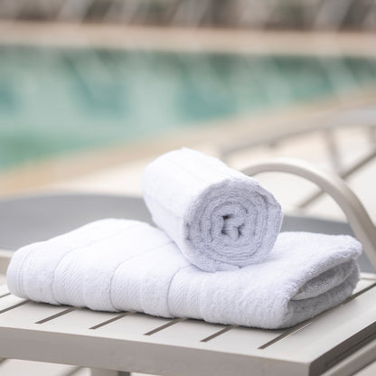 White Melluva Turkish cotton towel rolled on a poolside lounger